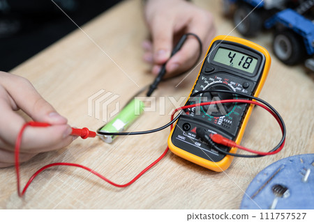 the engineer measures the voltage on the battery with a multimeter the engineer measures the voltage on the battery with a multimeter 111757527