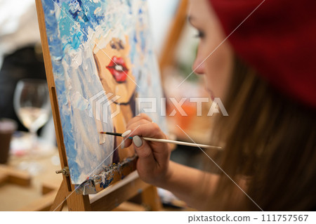 girl artist paints a picture on canvas with oil paints 111757567
