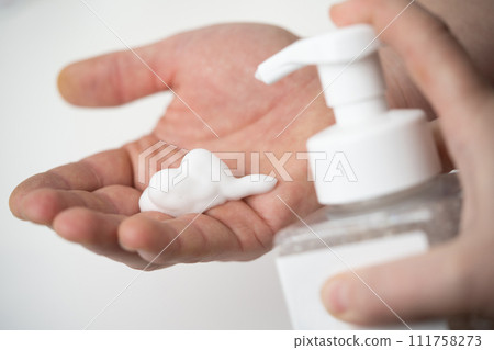 applying and rubbing the cosmetic product from the bottle into the hand 111758273