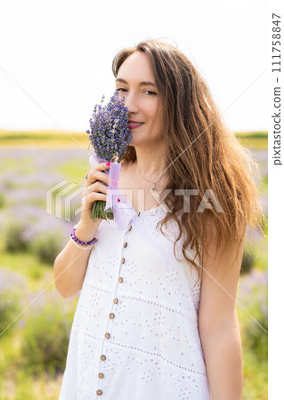 beautiful girl in a dress on a lavender field with a bouquet of flowers 111758847
