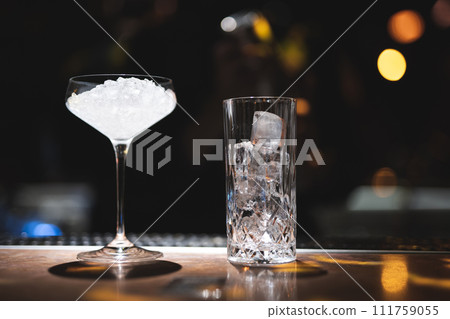 the bartender prepares a beautiful alcoholic cocktail at the bar counter 111759055
