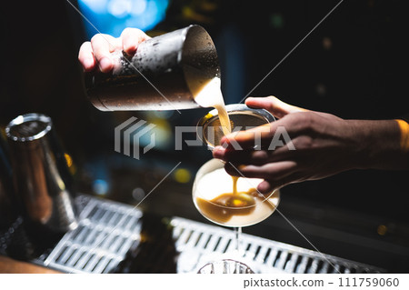 the bartender prepares a beautiful alcoholic cocktail at the bar counter 111759060