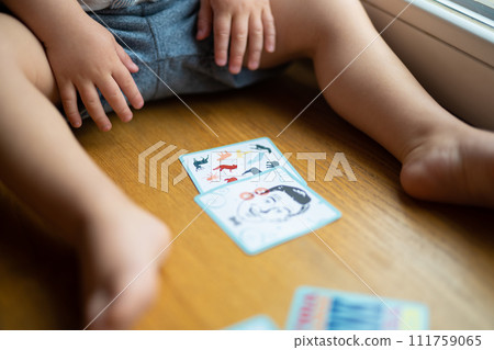 a small child plays with developing cards from a board game 111759065