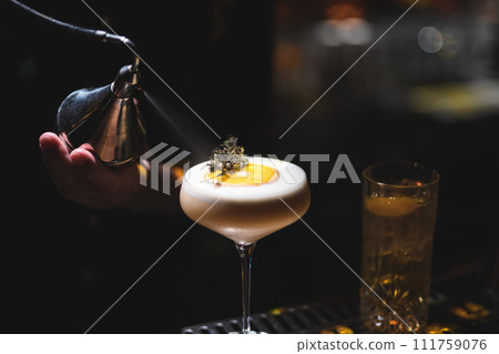 the bartender prepares a beautiful alcoholic cocktail at the bar counter 111759076
