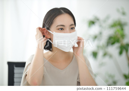 戴著面具在辦公室的年輕女商人 戴著面具在辦公室的年輕女商人 111759644