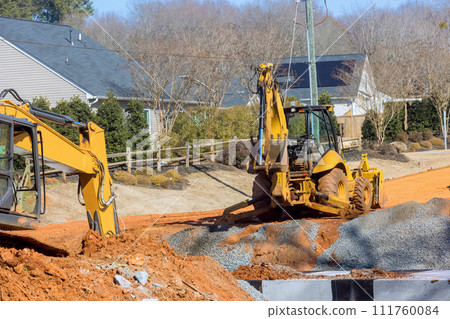 During earthmoving operations to prepare an infrastructure area, an excavator digs trenches During earthmoving operations to prepare an infrastructure area, an excavator digs trenches 111760084