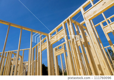 Wood frame of new house during construction, framed by timber wood stick frames 111760096