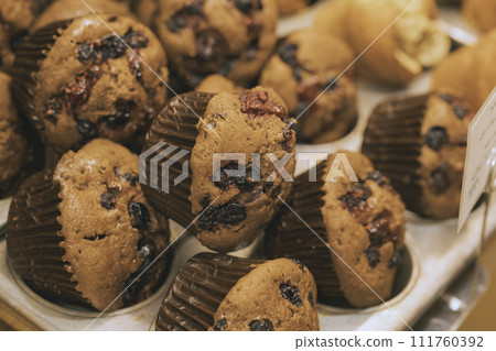 In-store display of chocolate muffins with berries and cupcakes 111760392