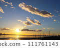 Winter sky dyed by the setting sun and underwater utility poles 111761143