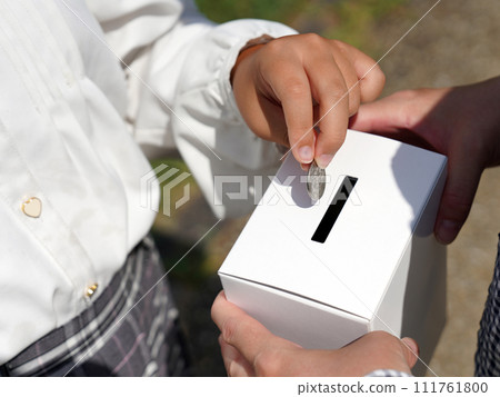 Hand donating to donation box 111761800