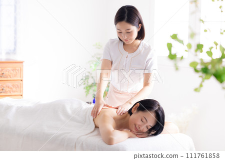Middle-aged woman and esthetician receiving a massage 111761858