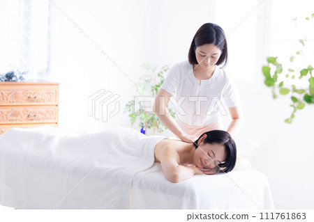 Middle-aged woman and esthetician receiving a massage Middle-aged woman and esthetician receiving a massage 111761863