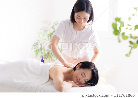 Middle-aged woman and esthetician receiving a massage Middle-aged woman and esthetician receiving a massage 111761866