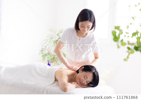 Middle-aged woman and esthetician receiving a massage Middle-aged woman and esthetician receiving a massage 111761868