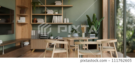 The interior design of a modern green office lounge or break room with a dining table and decor. The interior design of a modern green office lounge or break room with a dining table and decor. 111762605