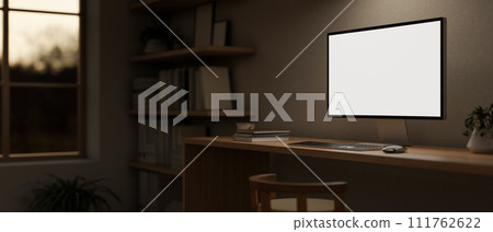 A minimal cosy home office workspace in the evening with a computer mockup on a wooden desk. 111762622