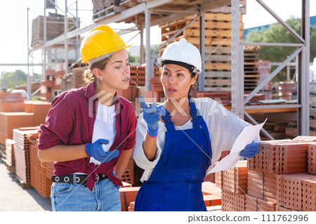 Couple of female wokers checking order list Couple of female wokers checking order list 111762996