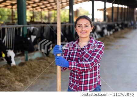 Woman farmer posing at cowshed on farm 111763070
