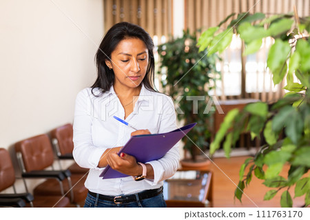 Smiling latin american woman business assistant noting tasks 111763170