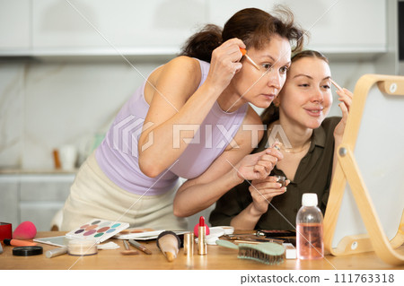 Two besties doing everyday makeup together in front of mirror Two besties doing everyday makeup together in front of mirror 111763318