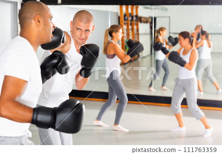 Two men practicing self defense techniques in sports club 111763359
