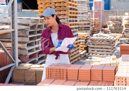 Asian female worker keeps records of ceramic tiles Asian female worker keeps records of ceramic tiles 111763514