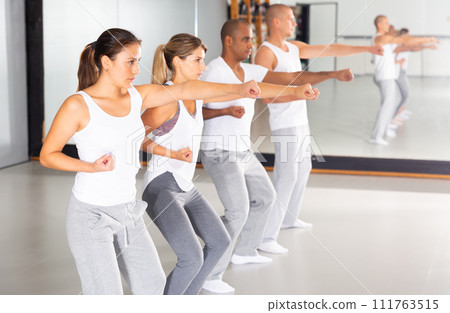 Group of people practicing self defense movements in training room 111763515