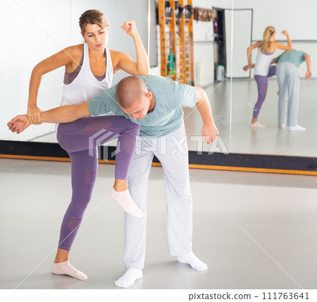Girl practicing effective self defence techniques in training room 111763641