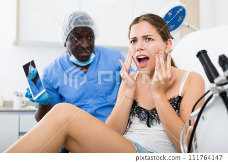 Dissatisfied woman examining face after cosmetology procedures Dissatisfied woman examining face after cosmetology procedures 111764147