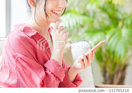 A young woman operating a smartphone. (parts) 111765218