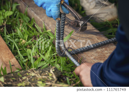 Construction Worker hands using pincer pliers iron wire. Outdoor Worker using wire bending pliers, construction work. Men hands bending cutting steel wire fences bar reinforcement of concrete work 111765749
