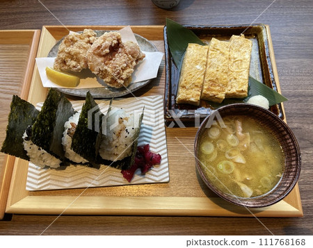 A set meal consisting of rice balls, pork miso soup, fried chicken, and rolled omelet. A set meal consisting of rice balls, pork miso soup, fried chicken, and rolled omelet. 111768168