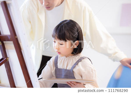 Painting class: A girl draws on the campus while receiving guidance from her teacher Painting class: A girl draws on the campus while receiving guidance from her teacher 111768290