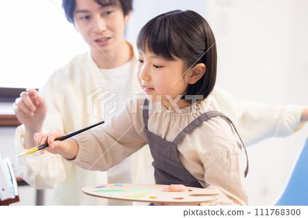 Painting class: A girl draws on the campus while receiving guidance from her teacher 111768300