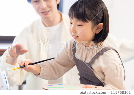 Painting class: A girl draws on the campus while receiving guidance from her teacher 111768301