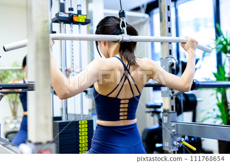 女人在健身房訓練身體，高位下拉，肌肉訓練女孩的背部鍛煉，顯然 111768654