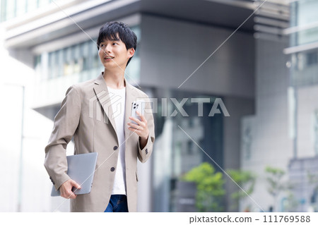 一個年輕的商人在戶外散步 111769588