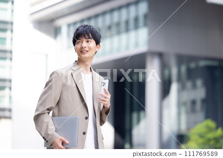 一個年輕的商人在戶外散步 一個年輕的商人在戶外散步 111769589