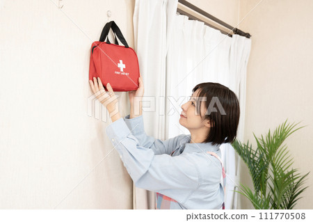 A woman with an emergency bag hanging on the wall A woman with an emergency bag hanging on the wall 111770508