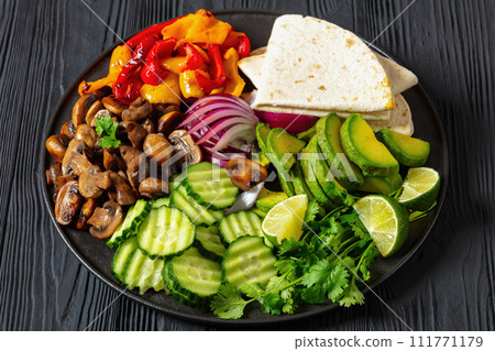 vegan fajitas with mushrooms, veggies on a plate vegan fajitas with mushrooms, veggies on a plate 111771179
