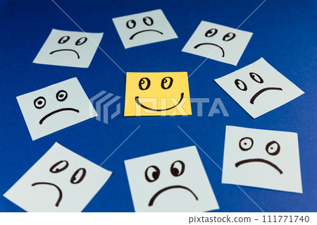 Sticky notes with hand drawn Smiley face and Sad faces on blue background. Positive way of thinking concept Sticky notes with hand drawn Smiley face and Sad faces on blue background. Positive way of thinking concept 111771740