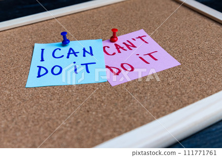 I can do it and I can't do it phrases written on sticky notes pinned at cork board 111771761