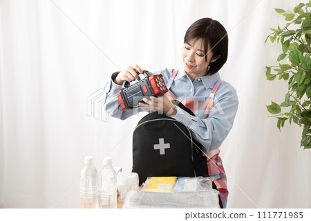 一名婦女正在檢查應急包中的物品 111771985