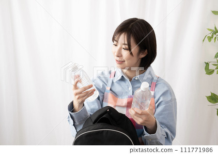 一名婦女正在檢查應急包中的物品 111771986