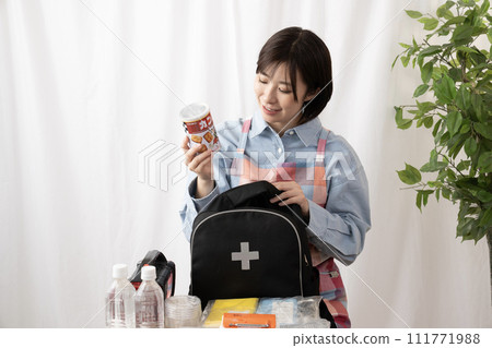 一名婦女正在檢查應急包中的物品 一名婦女正在檢查應急包中的物品 111771988
