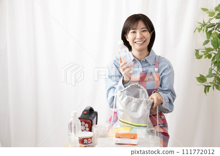 A woman checking the contents of an emergency bag 111772012