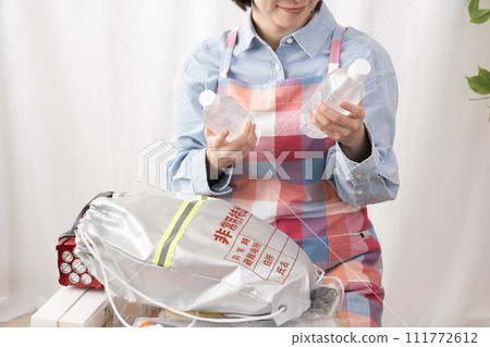 一位女士的手檢查應急包的內容 111772612