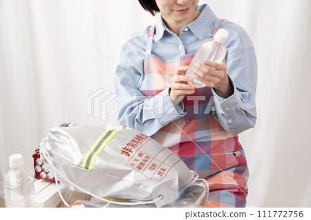 一位女士的手檢查應急包的內容 111772756