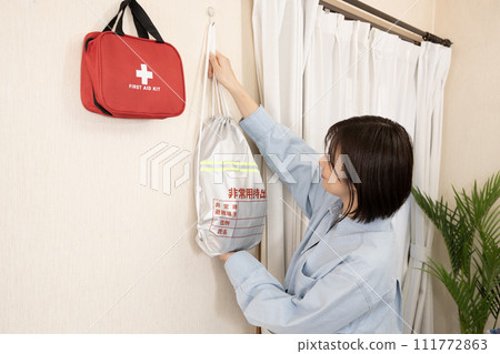 A woman with an emergency bag hanging on the wall 111772863
