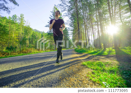 Man jogging in city partk at beautiful summer day. Sport fitness model caucasian ethnicity training outdoor. 111773095